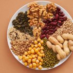 Top view of nuts, beans, and seeds on a plate, ideal for healthy dining themes.